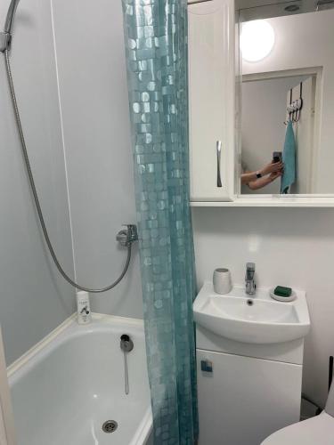 a bathroom with a sink and a shower curtain at Comfort Haven Apartments in Jõhvi