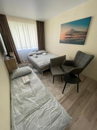 a bedroom with a bed and a desk and a chair at Comfort Haven Apartments in Jõhvi