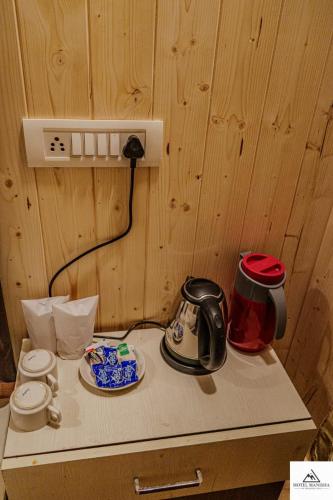 a counter with a tea kettle and plates on it at HOTEL MANISHA in Gangotri