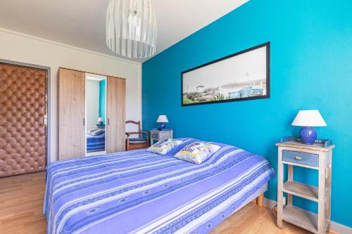 a blue bedroom with a bed with a blue wall at Appartement À Saint-Pierre-d'Oléron in Saint-Pierre-dʼOléron