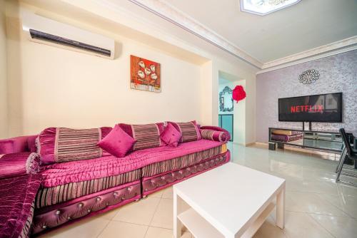 a living room with a couch and a tv at First Line Beach & Free Parking in Tangier