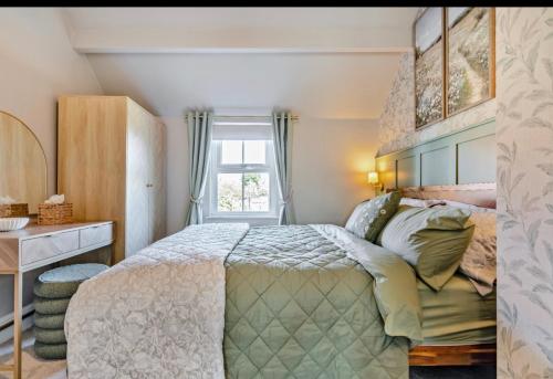a bedroom with a bed and a window at Ivydene Cottage Hawsker in Whitby