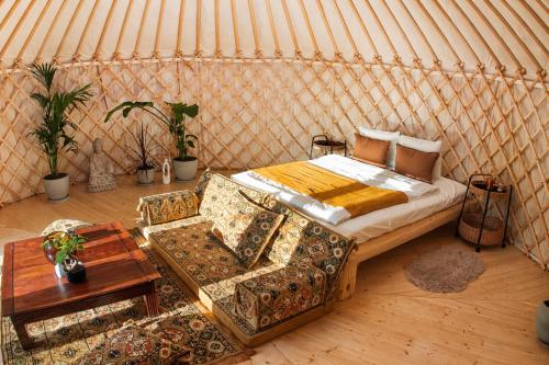 a bed in a yurt with a table and chairs at WoodMood in Leuk