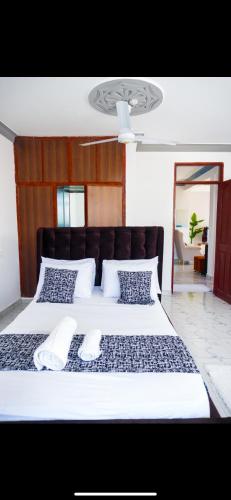 a bedroom with a large bed with white sheets and pillows at Malindi Leisure homes in Malindi