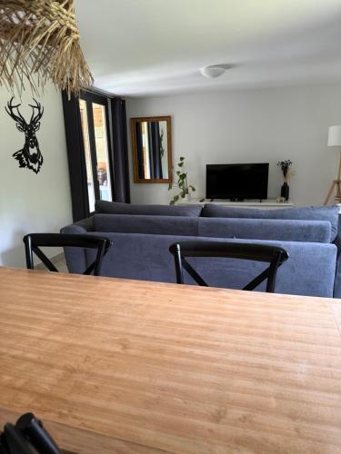 a living room with a couch and a table at Le refuge de Chambord Nature, calme, forêt et prestige des châteaux de la Loire in Thoury