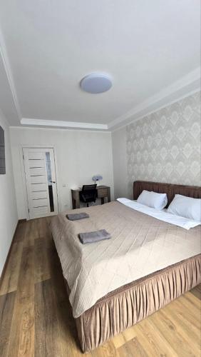 a bedroom with a large bed and a desk at Однокімнатні апартаменти в новому ЖК in Vasylʼkiv