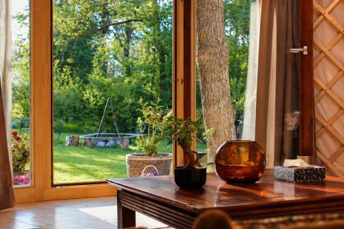 a table with a vase on top of it in front of a window at WoodMood in Leuk