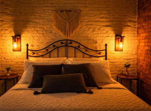 a bedroom with a large bed with two lights on it at Vale Infinito Chalé in Córrego do Bom Jesus