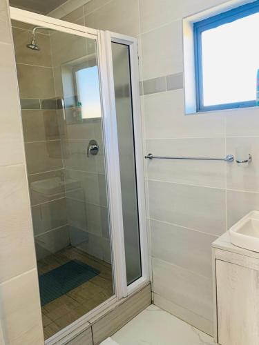 a shower with a glass door in a bathroom at Solovina Guest House in Foso