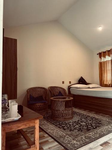 a room with a bed and chairs and a table at Prashiddha Resort in Dakshīnkāli