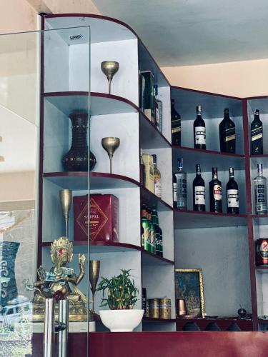 a glass shelf with bottles on it at Prashiddha Resort in Dakshīnkāli