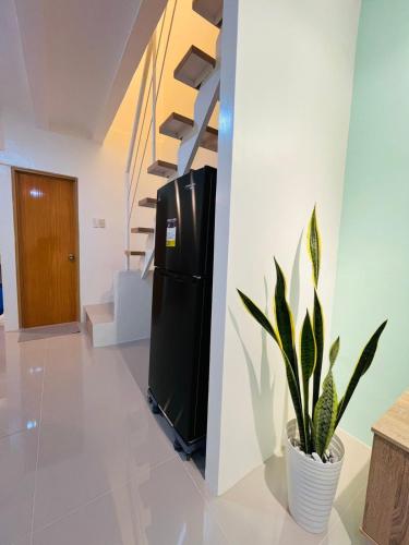 a black refrigerator in a room with a plant at Casa Serenity Transient House in General Trias