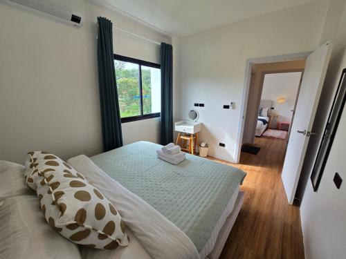 a bedroom with a bed and a large window at Live With Passion Pool Villa in Pak Chong