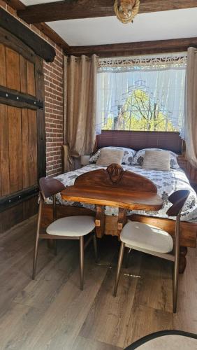 a bedroom with a wooden table and a bed at Pokój SERCE KRYNICY in Krynica Morska