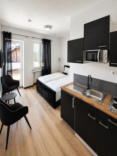 a bedroom with a bed and a kitchen with a sink at FeWo- Room Rental Rheine in Rheine