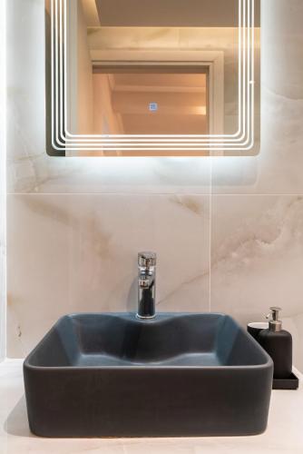 a black sink in a bathroom under a mirror at Dimasti Apartment in Rhodes Town