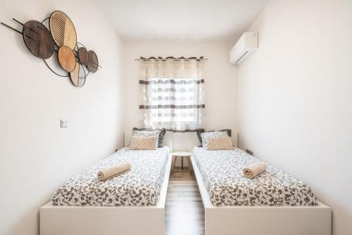 two beds in a room with a window at Dimasti Apartment in Rhodes Town