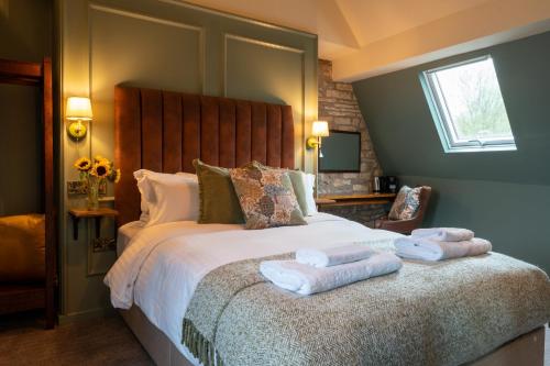 a bedroom with a large bed with two towels on it at The Rising Sun - Pensford in Pensford