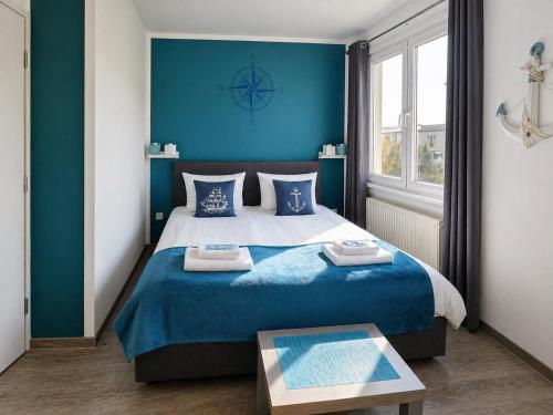 un dormitorio con una cama grande y paredes azules en Elbhotel Dresden by AURUM, en Dresden