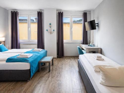 una habitación de hotel con dos camas y una mesa en Elbhotel Dresden by AURUM, en Dresden