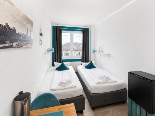 ein Zimmer mit zwei Betten und einem Fenster in der Unterkunft Elbhotel Dresden by AURUM in Dresden
