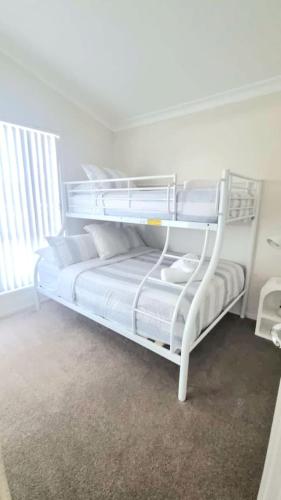 a white bunk bed in a white room at Serena Shores Holiday Escape in St Georges Basin
