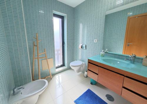 a bathroom with a tub and a sink and a toilet at Casa Joaninha in Olhão