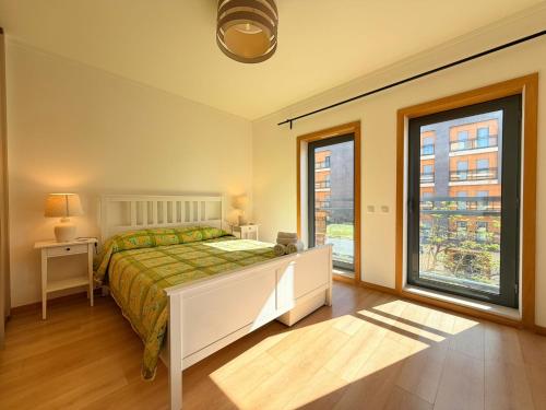 a bedroom with a bed and a large window at Casa Joaninha in Olhão