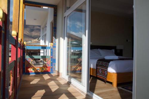 a room with a bedroom with a bed and a window at Hotel Ugyen, Thimphu in Thimphu
