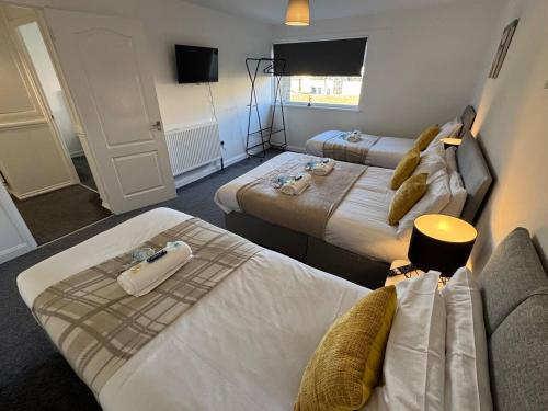 a hotel room with two beds and a couch at Chapelhall Contractor Stay in Chapelhall