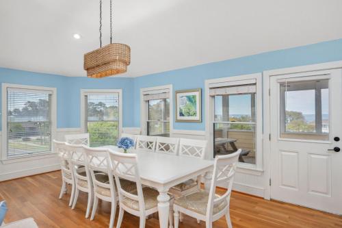 a dining room with a white table and chairs at Heron Landing in Corolla