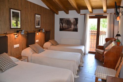 CabóにあるCasa Carlotaのベッド3台とバルコニーが備わるホテルルームです。
