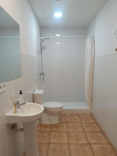 a white bathroom with a toilet and a sink at Nest Room in Alicante