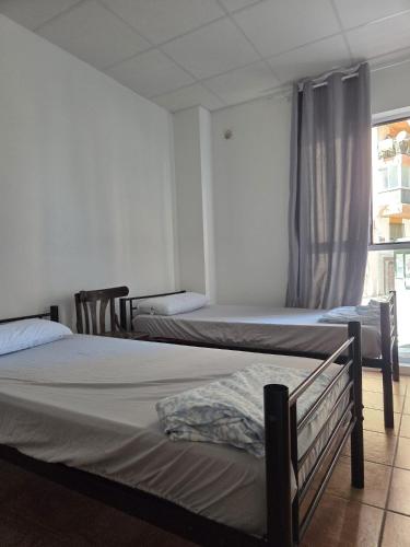 a bedroom with two beds and a window at Nest Room in Alicante