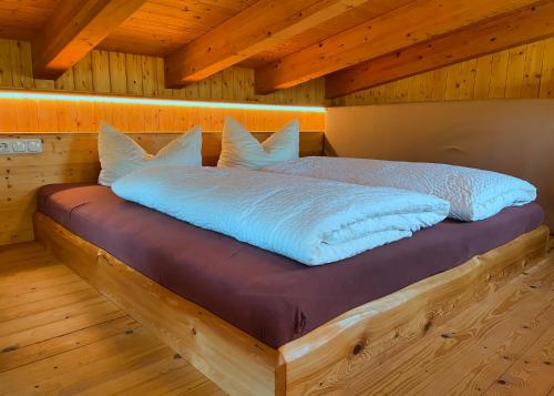 a bed in a room with a wooden ceiling at Ferienhaus Siebenschläfer im Sandsteinidyll in Rathen