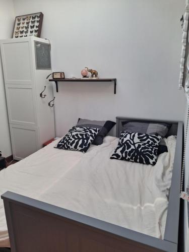 a bed with two pillows on it in a bedroom at Independent studio in Pont-lʼAbbé