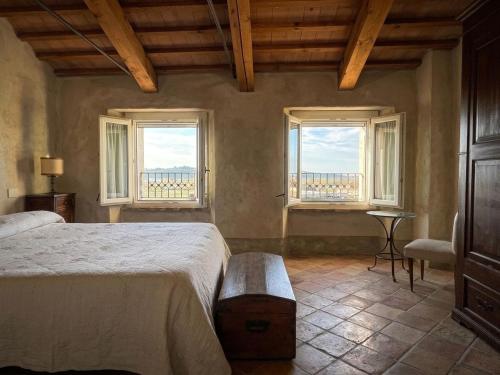 a bedroom with a bed and two windows at La chesa de Prit in Verucchio