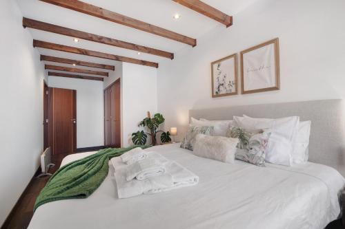 a white bed with towels on it in a bedroom at Flor de Sol House in Tavira
