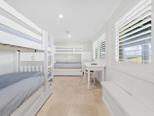 a bedroom with a bed and a desk and windows at Elysian Shores in Long Beach