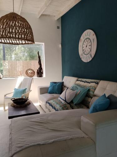 a living room with a couch and a clock on the wall at Bosque del Este in Balneario Buenos Aires