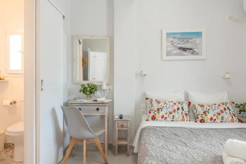 a bedroom with a bed and a chair and a mirror at Angeliki Pension in Katapola