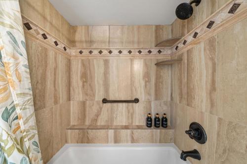 a bath tub in a bathroom with wooden walls at Maui Beachfront Haven 433 in Lahaina