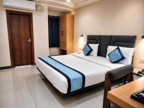 a bedroom with a large bed and a desk at Hotel Konark Inn in Indore