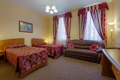 Habitación de hotel con 2 camas y sofá en Hotel Piipun Piha en Sortavala