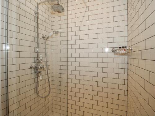 a white tiled shower with a glass shower backdoor at The Old China Shop in Ludlow