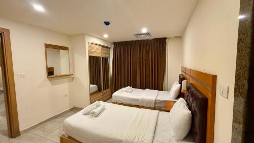 a hotel room with two beds and a mirror at Jawheret S Hotel Suite in Amman