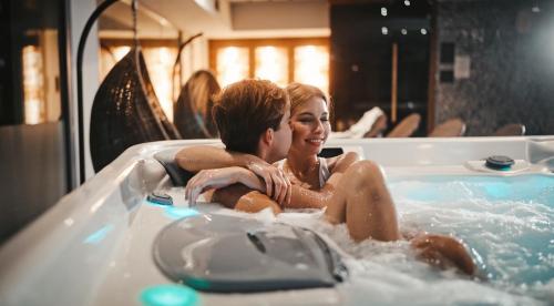 a man and a woman sitting in a bathtub at Hotel Memories OldTown in Budapest