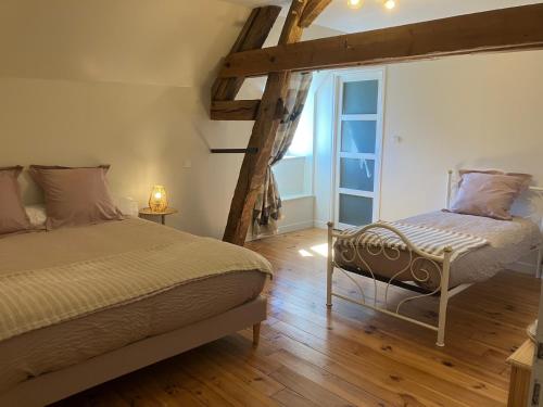 a bedroom with two beds and a window at L'Auberge de Reullée in Marigny-lès-Reullée