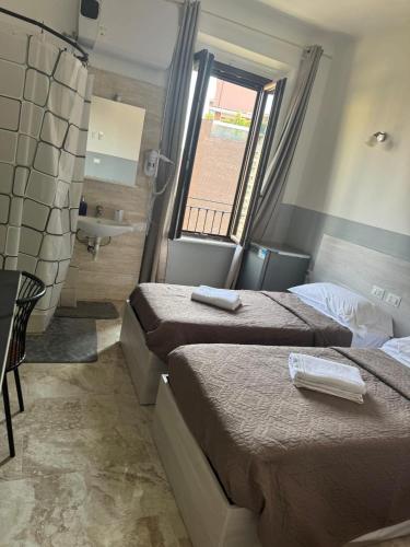 a hotel room with two beds and a sink at Hotel Emmy in Milan