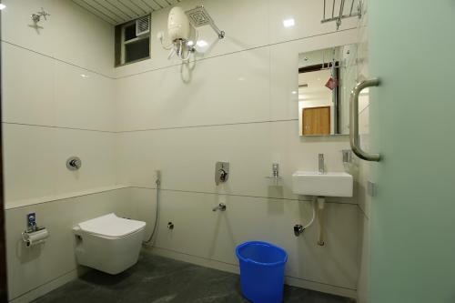 a bathroom with a toilet and a sink at Nova Yashraj Hotel in Rajkot